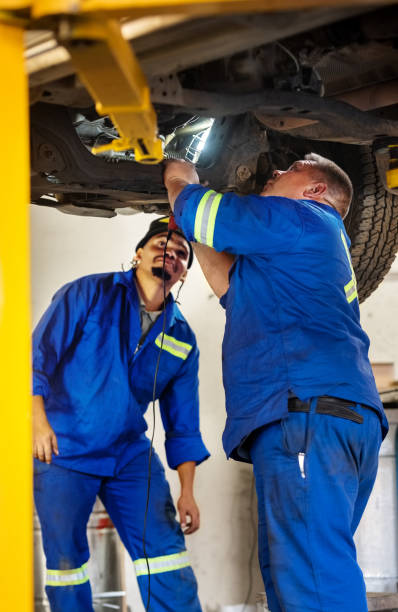 mechaniker prüfen schäden an einem auto - maintenance engineer car lamp protective workwear stock-fotos und bilder