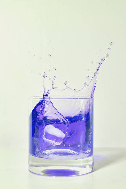 istock ice cube falling in a glass with purple liquid 1295095484