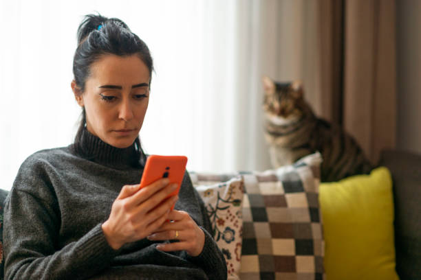 Woman looking at mobile phone screen at home.