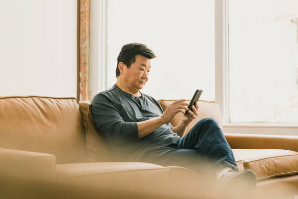 istock Senior man uses smartphone at home 1295099798