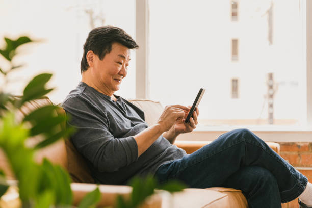 istock Confident senior man uses smartphone at home 1295099803