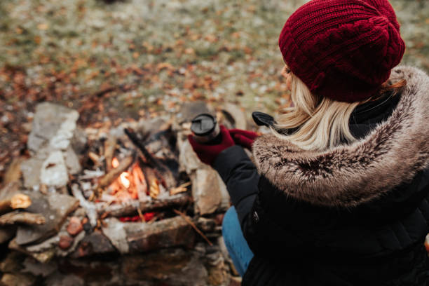 istock Young female sitting by the bonfire 1295100054