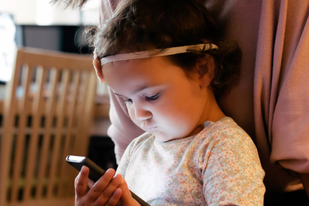 istock Little girl using mobile phone at home. 1295101669