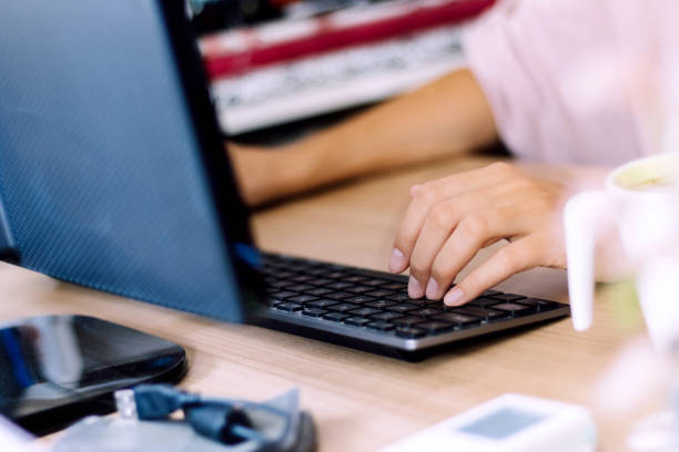 istock Close-up of woman working on a computer and typing an e-mail. 1295101784