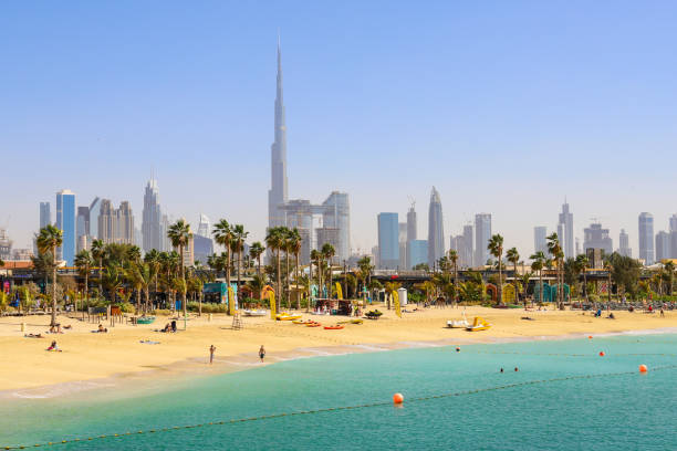 Dubai beach La Mer, people rest, in the distance the skyscrapers of the city. Dubai beach La Mer, people rest, in the distance the skyscrapers of the city. United Arab Emirates Dubai March 2019 jumeirah stock pictures, royalty-free photos & images