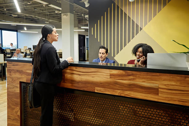 istock Female Client Speaking to Receptionist in Modern Office 1295108973