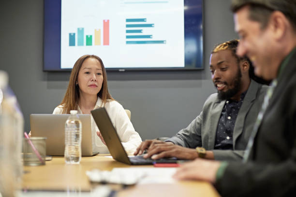 istock Asian, Black, and Hispanic Colleagues Working in Board Room 1295109016