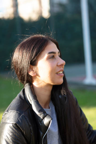 istock beautiful Young woman sitting on a bench 1295111414