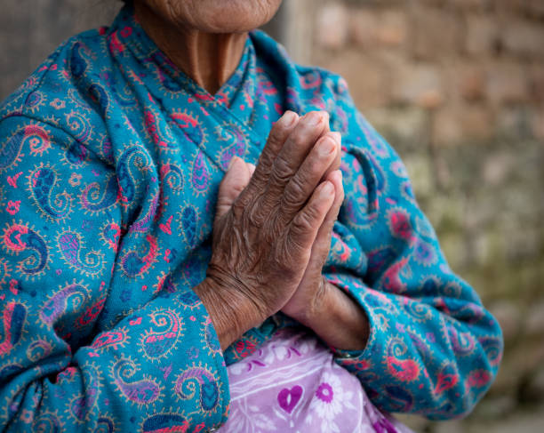 mulher mais velha não reconhecida usando panos azuis cruzando suas mãos enrugadas. processo de envelhecimento - unrecognized person - fotografias e filmes do acervo