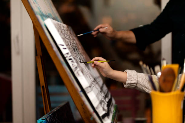 istock Father is imitateing her son while he is painting 1295132102