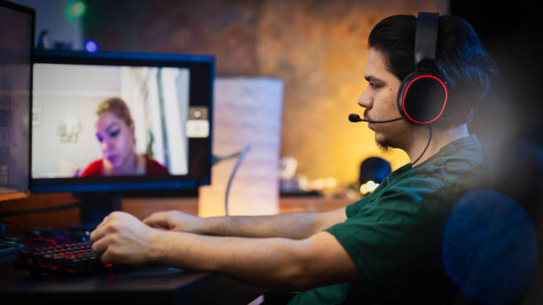 istock Teenage Boy Playing Multiplayer Games on Desktop Pc in his Dark Room 1295133377