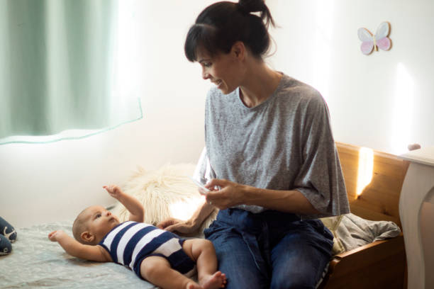 istock mother taking the temperature to her baby 1295141736