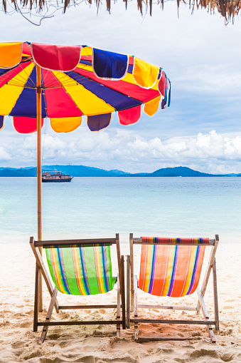 Two colorful beach chair with umbrella on the beach