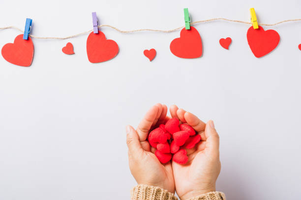 istock Woman hands holding red heart present decorated surprise 1295148947