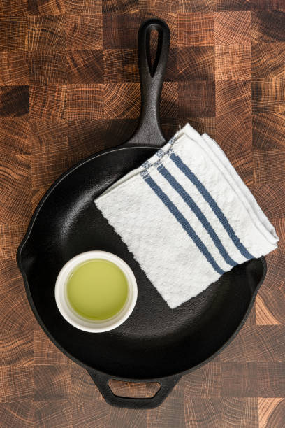 Cast Iron Skillet, towel and oil on a kitchen counter