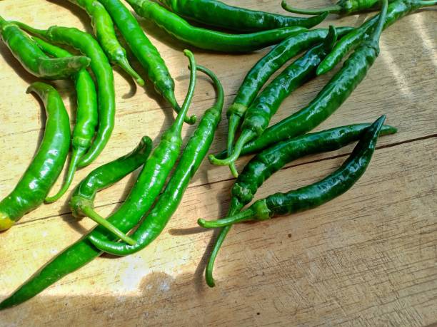 istock green curly chilies on a wooden plank background 1295153520