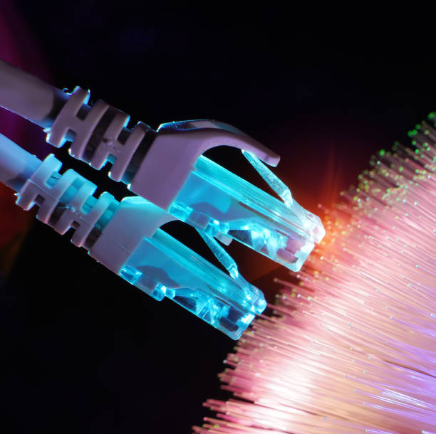 istock Network cable with high tech technology Fiber optical color background 1295155635