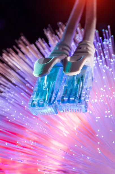 istock Network cable with high tech technology Fiber optical color background 1295155645