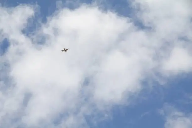 Airplane (biplane) flying in a cumulus clouds in Hawaii.