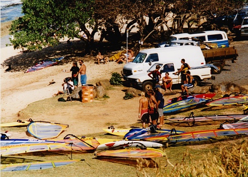 Maui, Hawaii, USA – April 22, 2003: Windsurfers gather on a beach in Maui.