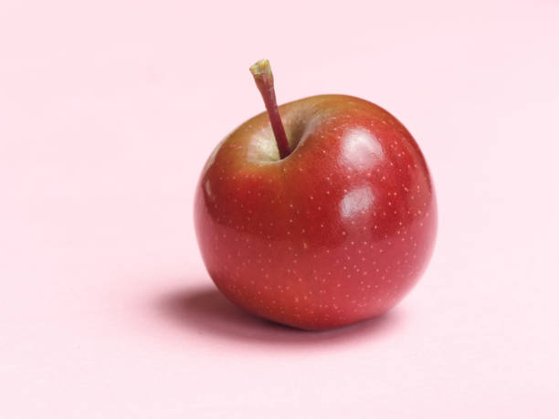 istock Cute red apple isolated on pink background, studio shot. 1295163932