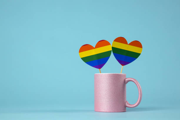istock Pink coffee mug with LGBT symbol on blue background 1295187036