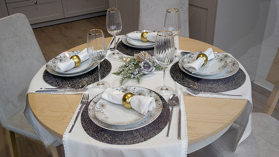 Close up view of modern elegant well-laid table ready for a Christmas celebration event .