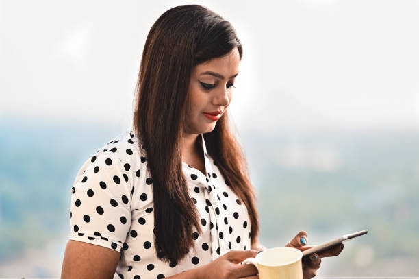 istock Smiling businesswoman using tablet in balcony with tea or coffee cup in Hand. 1295205685