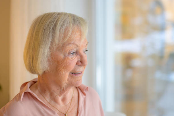istock Thoughtful senior lady staring out of a window 1295206212