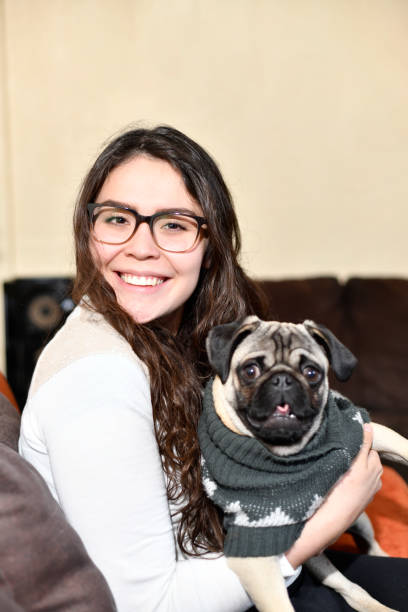 istock Young woman looking at her calm pug 1295206453