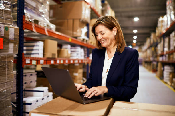 istock Female manager working at the Warehouse with a laptop. 1295207970
