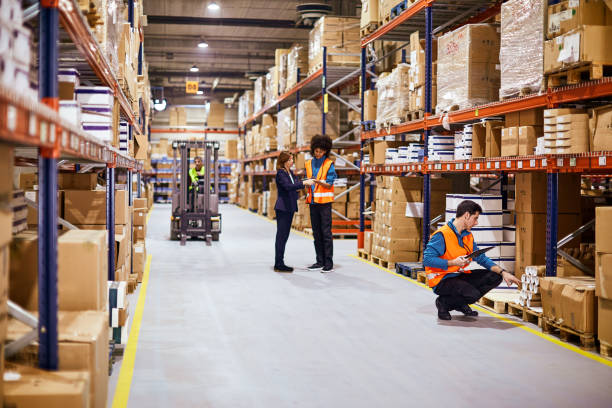 istock General view of a warehouse aisle with workers. 1295208018