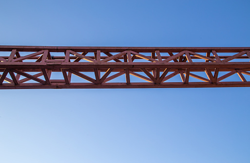 straight red steel welded girder beam on blue sky background