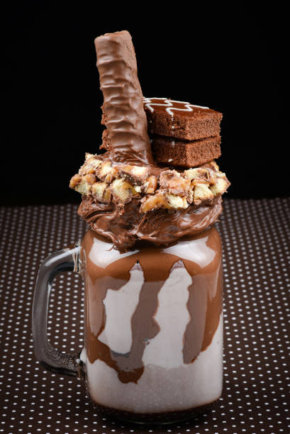 istock Chocolate extreme milkshake with brownie cake, chocolate paste and sweets. Crazy freakshake food trend. Copy space 1295209873