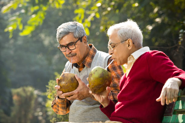 Senior men enjoying fresh coconut drink at park