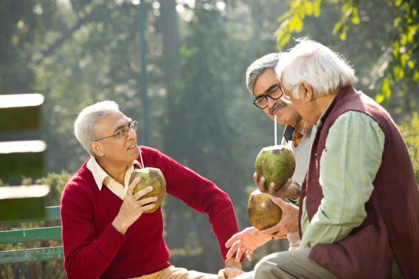 istock Senior men enjoying fresh coconut drink at park 1295212720