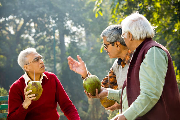 istock Senior men enjoying fresh coconut drink at park 1295212982