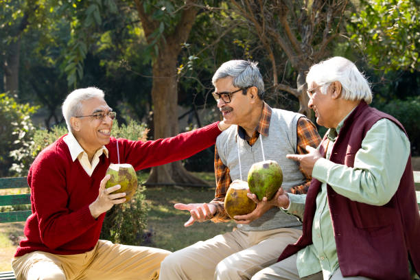 istock Senior men enjoying fresh coconut drink at park 1295213323