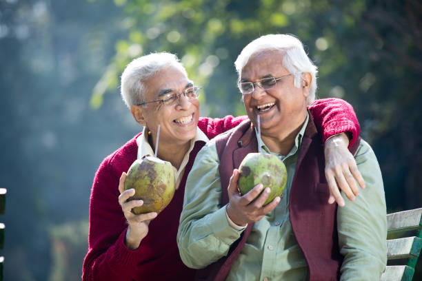 istock Senior men enjoying fresh coconut drink at park 1295214719