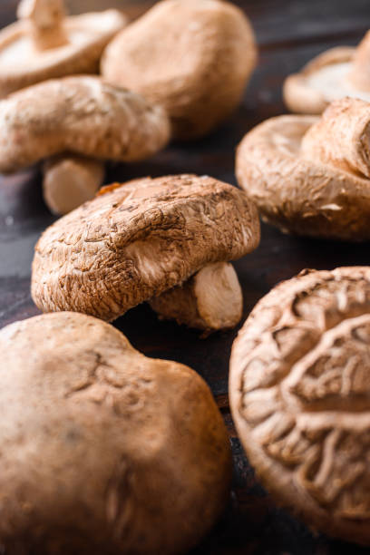 istock Shiitake mushrooms set on old wooden table, side view selective focus 1295215233