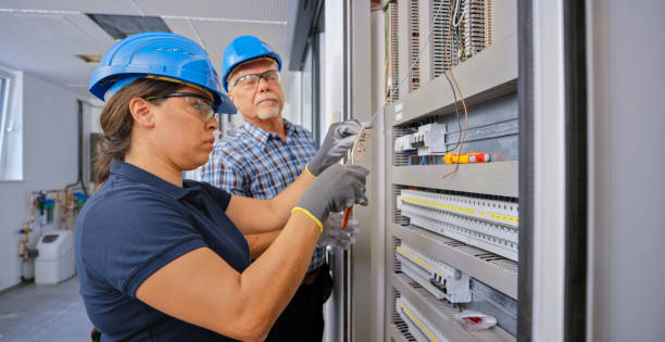 electrician teaching his apprentice to connect the wires - polo shirt two people men working imagens e fotografias de stock