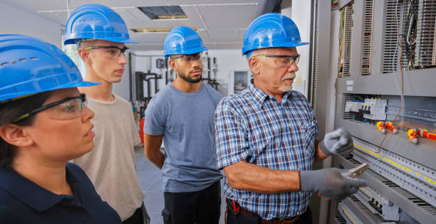 istock Electrician teaching his apprentices to connect the wires 1295215695