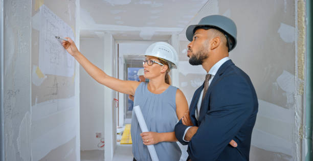 istock Architect discussing blueprint with coworker 1295215745