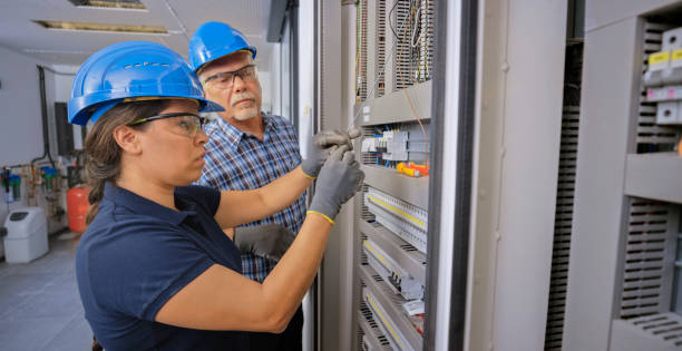 electrician teaching his apprentice to connect the wires - polo shirt two people men working imagens e fotografias de stock