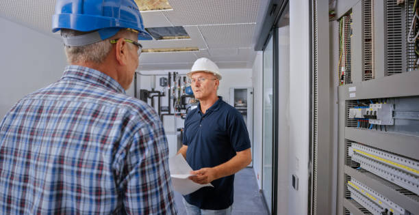 istock Electricians discussing blueprint 1295215786