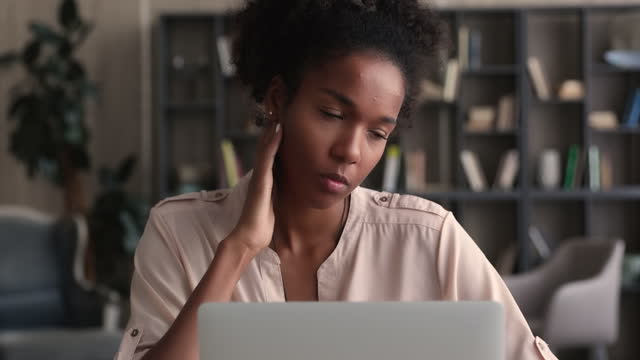 Focused african woman looking at laptop learn new app