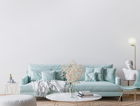 Trendy modern living room in light turquoise color and golden home accessories, empty wall mockup