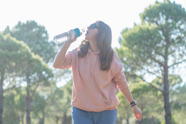 istock Women drinking water in forest. 1295220286