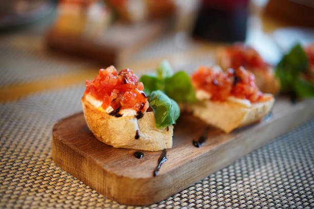 istock Bruschetta with tomatoes, mozzarella and basil on a cutting board. 1295223170
