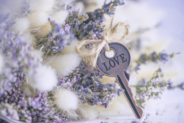 Hand Holding Two Keys and a Tag that Says Marriage